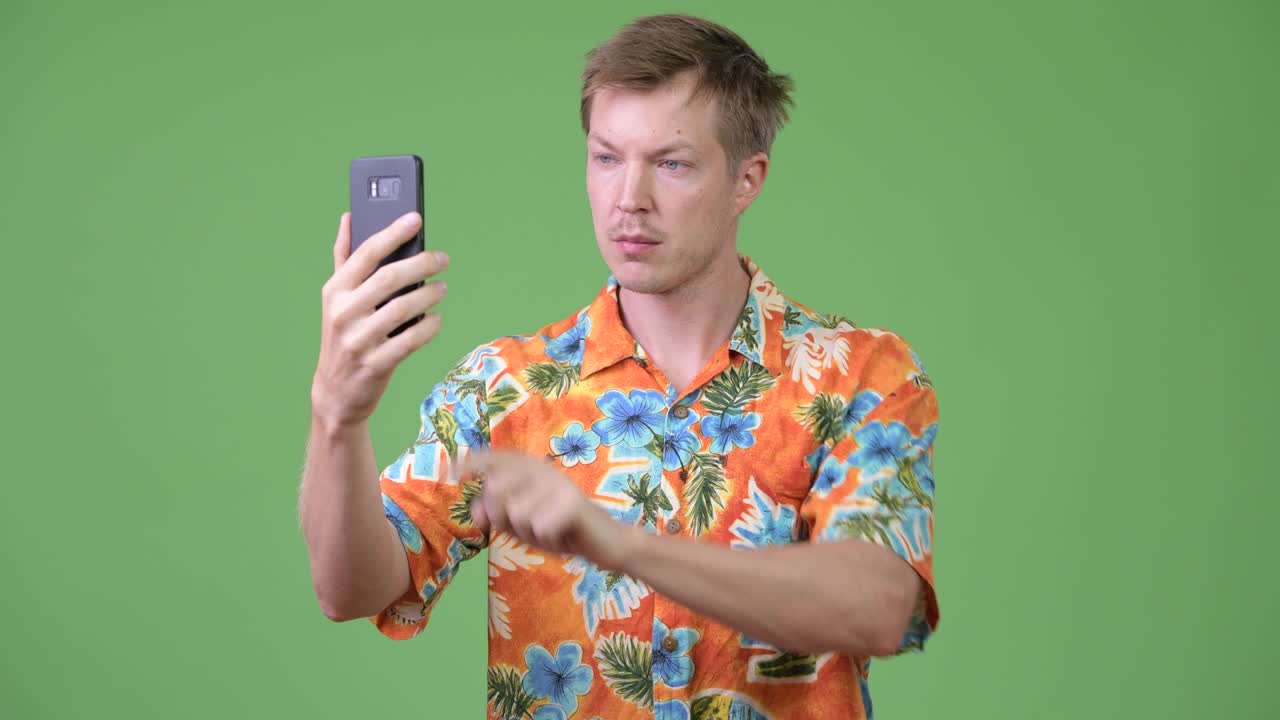 Mladý pohledný turista používající telefon