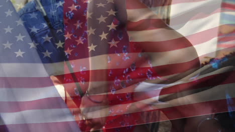 Holding-hands-and-embracing,-people-with-American-flag-animation-over-them