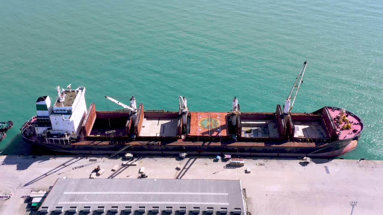 Aerial drone top view of containers cargo ship at industrial import-export port. Business logistic import and export freight transportation by container ship in open sea