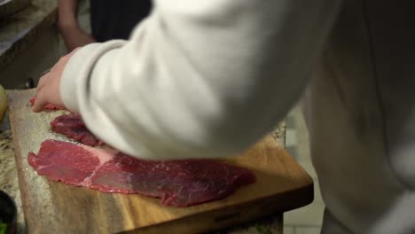 slicing steak on a cutting board in slow motion.
