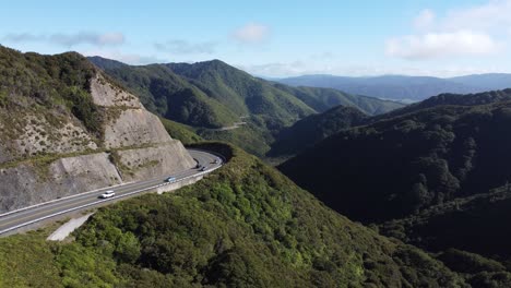 a static shot of a winding mountain road with cars driving on it