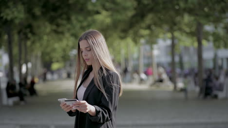 Girl-holding-credit-card-and-using-smartphone-outdoor