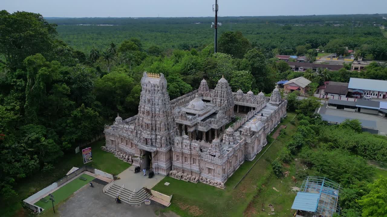 Ngoại thất đền Hindu trang trí công phu với tháp gopuram cao chót vót, những chạm khắc và tượng tinh xảo, được bao quanh bởi phong cảnh xanh tươi. Góc nhìn trên không tuyệt đẹp với flycam quay ngược toàn cảnh.