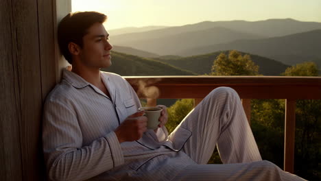 man relaxing with coffee on balcony