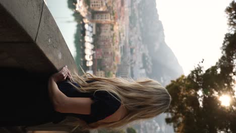 Mujer-Rubia-En-El-Balcón-Con-Vistas-A-Mónaco-Al-Atardecer,-Vertical-Cinematográfica