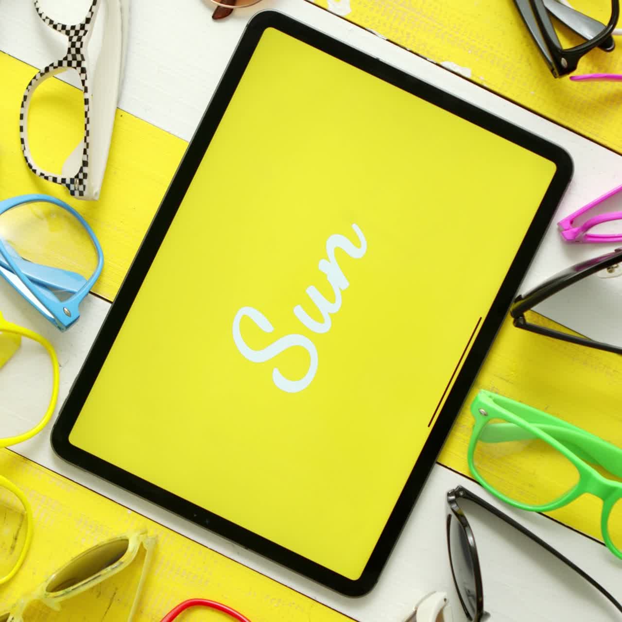 tableta de gafas de sol de varias formas y colores en el medio con sol de texto