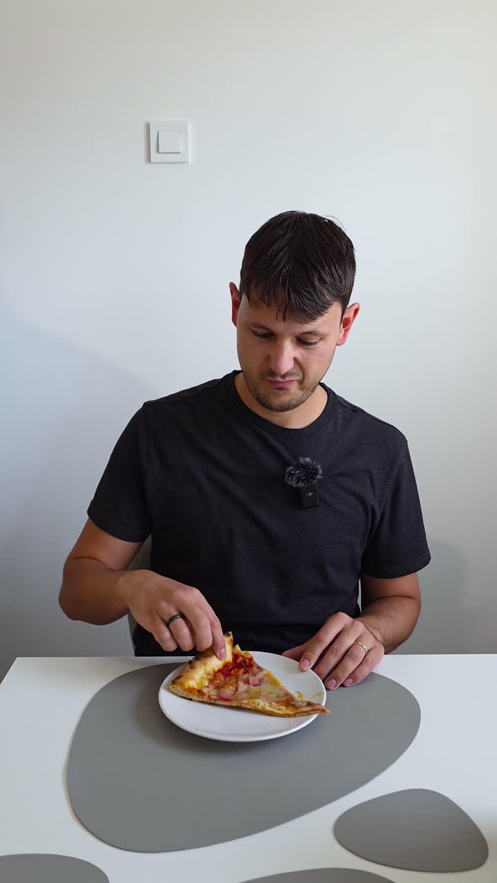 Vertical video of a man looking disgusted while inspecting a soggy slice of pizza. Ideal for food review, kitchen fail, taste test, bad delivery, or reaction-style content