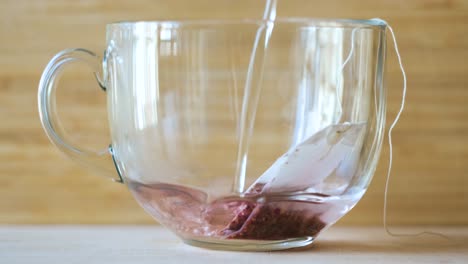 pink tea brewing in a glass cup