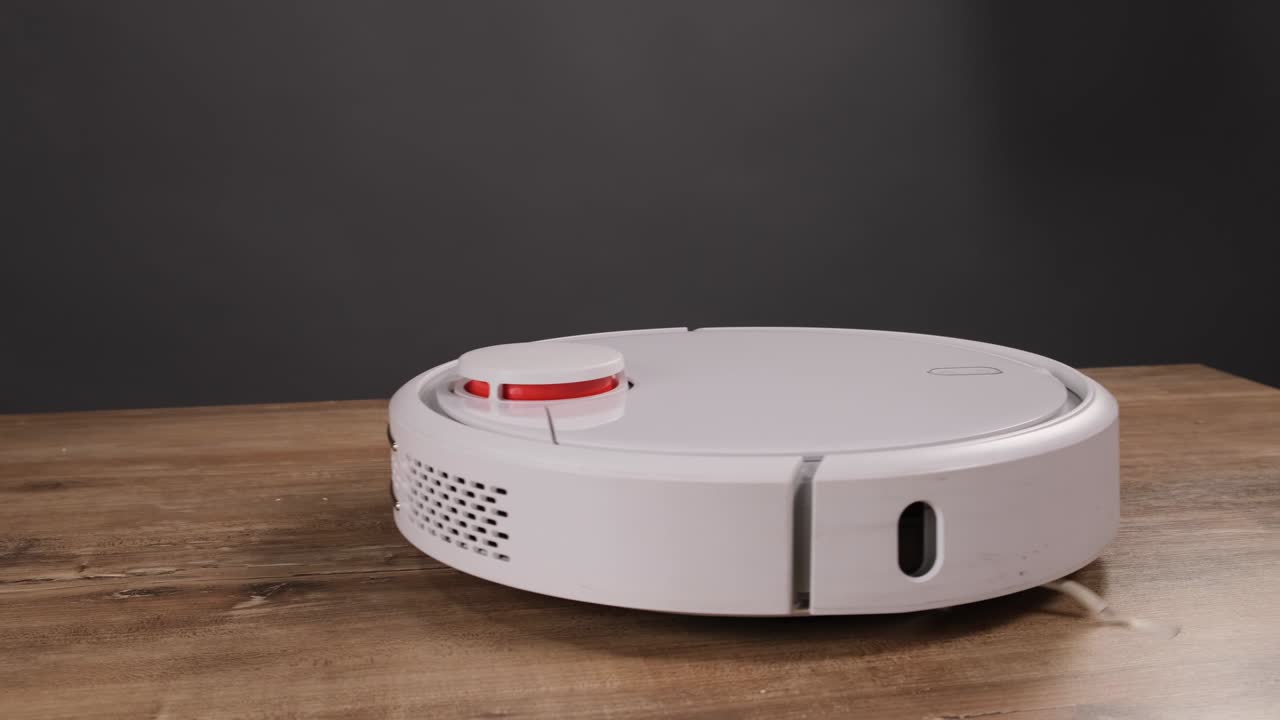 robot aspirador automático, máquina de piso limpio. robot aspirador limpieza automática en el hogar. aspirador robot realiza la limpieza automatizada del apartamento en un cierto momento.