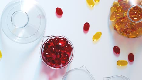 Seamless-looping-shot-with-red-and-yellow-gel-capsules-inside-laboratory-glassware-isolated-on-a-clean-white-surface.-Close-up-of-vitamin-supplement.-Healthy-lifestyle,-diet,-omega-3,-fish-oil-concept