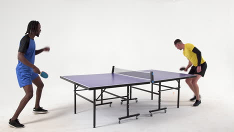 multiracial male table tennis players serving and passing the ball to each other on white background