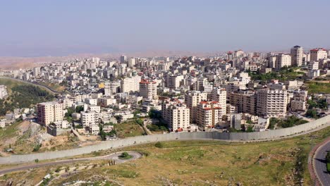 aerial view of a densely populated city with a security barrier
