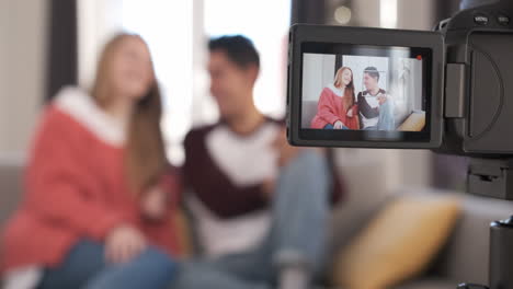 young couple talking to camera on screen. woman and man recording a video blog