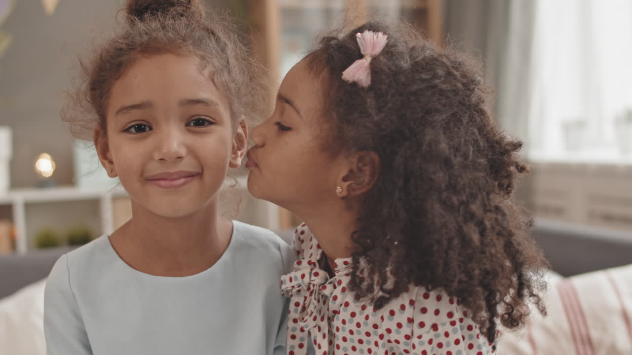 Cute Girl Kissing Sister on Cheek