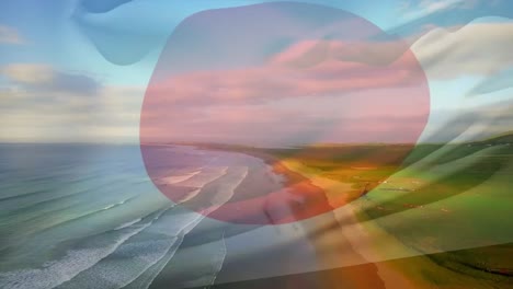 composición digital de la bandera de japón ondeando contra la vista aérea de la playa y las olas del mar