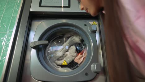 woman using a self-service washing machine