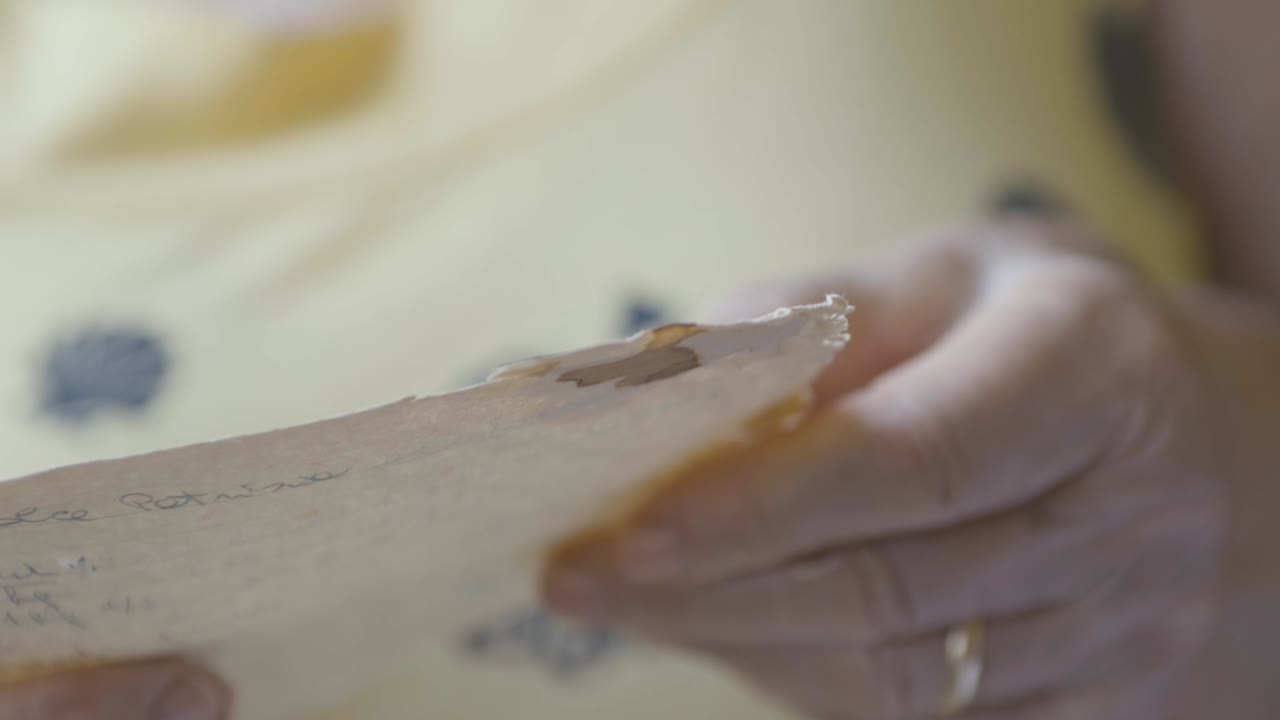 una señora relee una vieja receta escrita a mano muchos años antes por su abuela, pastel de vainilla y chocolate de dos sabores