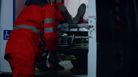 emergency doctors moving patient on stretchers into emergency car