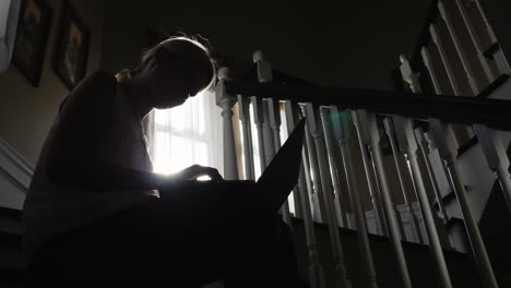 Woman-Uses-Laptop-on-a-Staircase