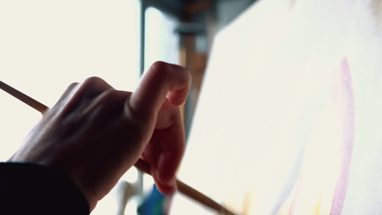 Close up of a woman painting on a canvas at an art gallery workshop