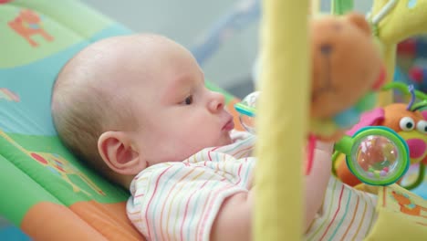 baby boy playing with toy. portrait of sweet kid playing with beanbag in bed