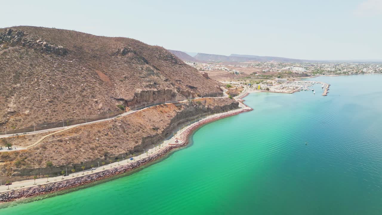 Aerial shot of Playa Coromuel, La Paz coastline with clear turquoise waters and rocky hills