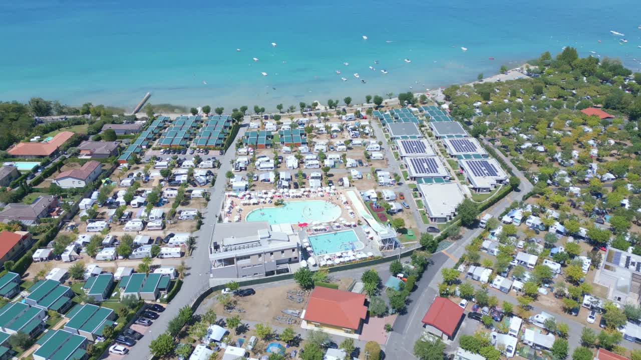 거대한 수영장과 테니스 코트가 있는 거대한 캠프장 리조트와 호수 전면 전망