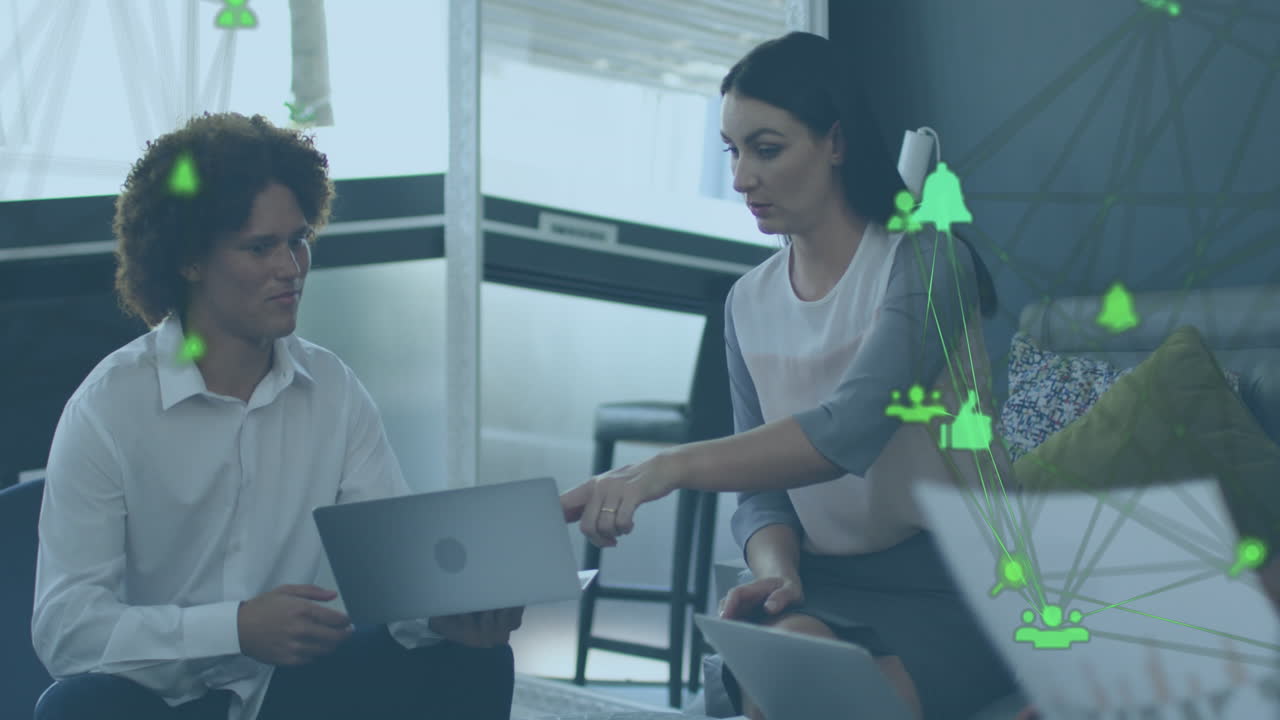 animación de un globo de iconos digitales sobre un hombre y una mujer diversos discutiendo sobre una computadora portátil en la oficina