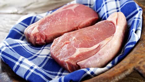 dos filetes crudos guardados en un paño en la bandeja