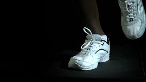 Legs-in-running-shoes-jogging-against-black-background