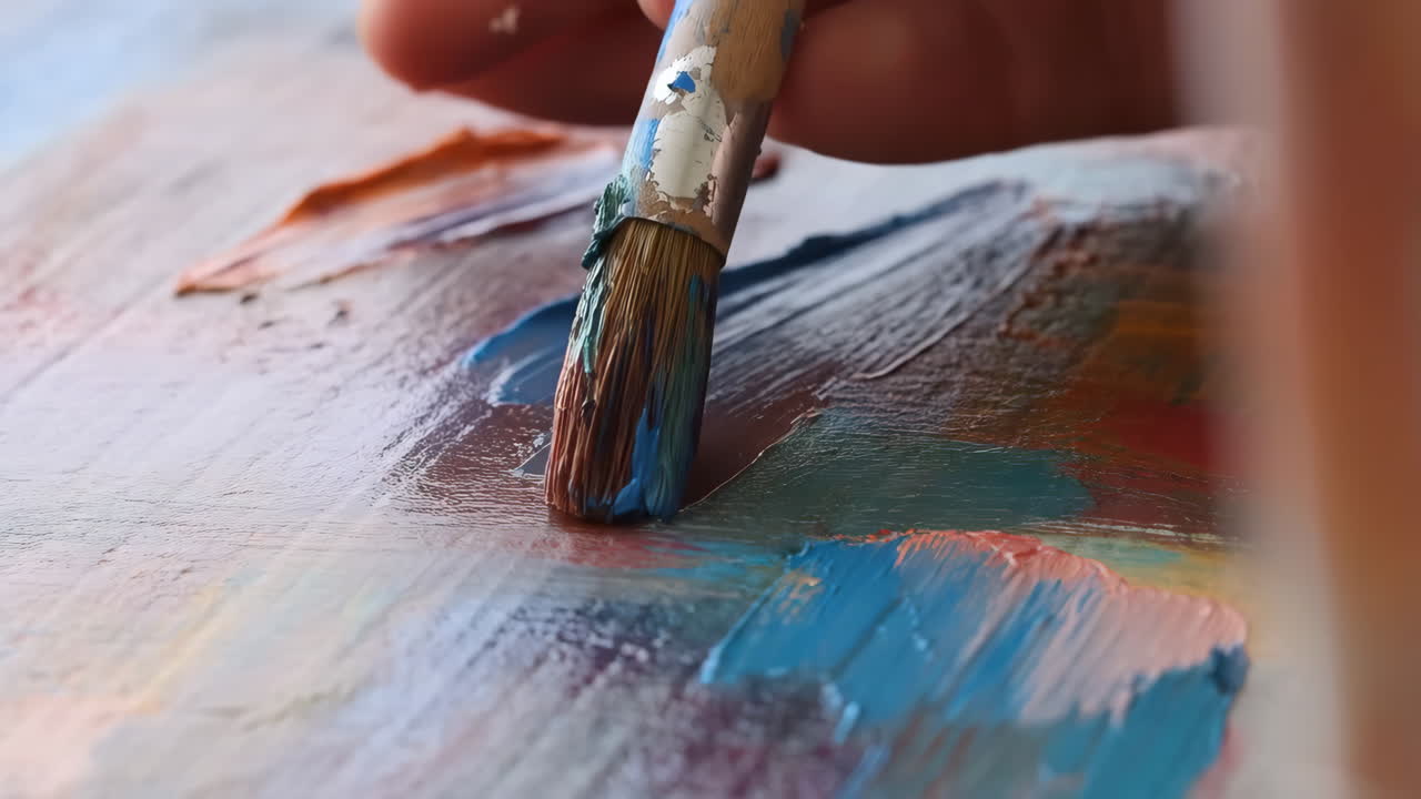 Close-up of an Artist's Hand with a Paintbrush on a Colorful Palette