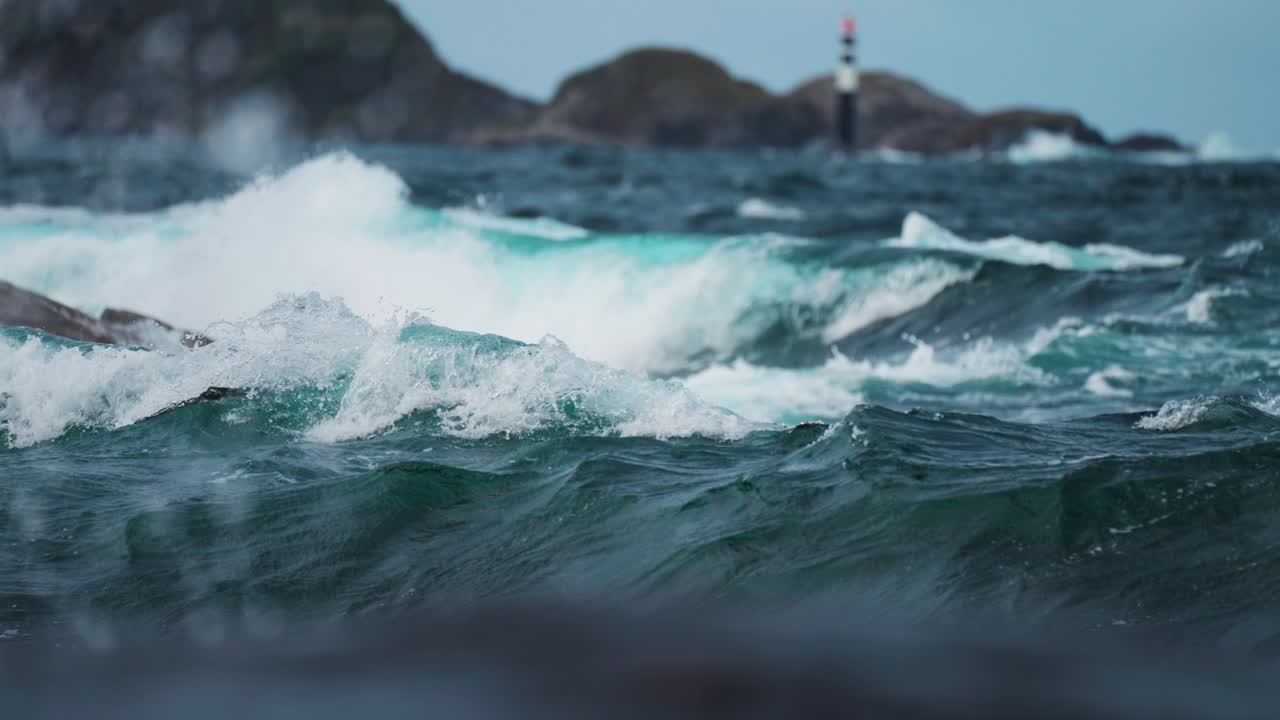 A lighthouse marks the rugged coastline along the Atlantic Road, surrounded by choppy waves and rocky waters.
