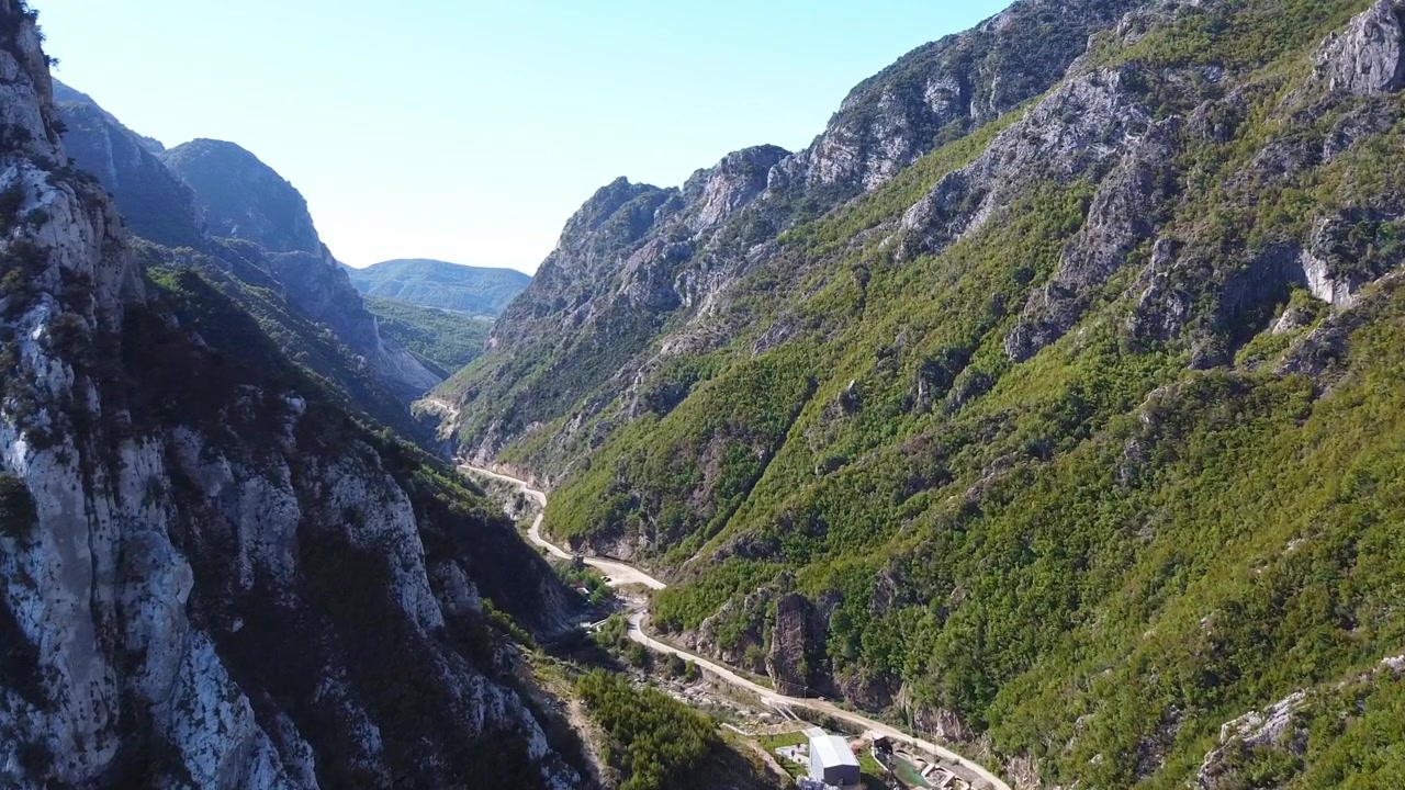 Vista aerea tra le montagne dell'Albania, con una strada che attraversa la valle, Lago di Bovilla