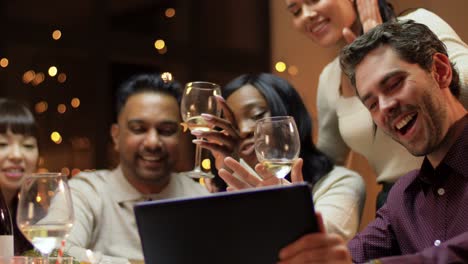 Vacaciones-De-Invierno,-Celebración-Y-Concepto-De-Personas.-Amigos-Felices-Con-Una-Computadora-Tablet-Haciendo-Una-Videollamada-En-La-Cena-Navideña-En-Casa.