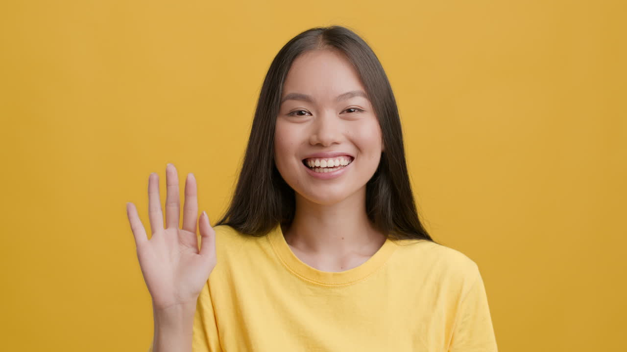 Young Asian Woman Waving and Smiling