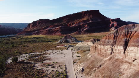 A-plain-crossed-by-a-road,-surrounded-by-mountains-slow-motion-over-paria-canyon