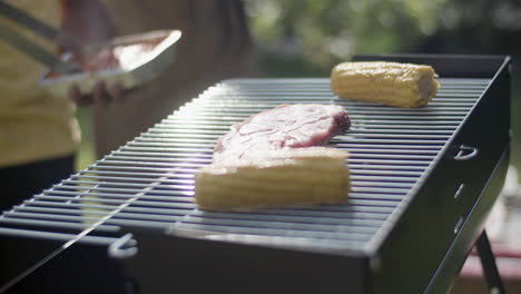primer plano de una parrilla de barbacoa caliente con maíz y carne