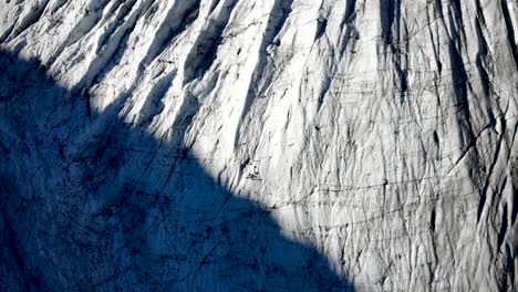 aerial flyover over morteratsch glacier in engadin, switzerland at dawn with a pan up towards some of the tallest peaks of the swiss alps like piz bernina, piz palu
