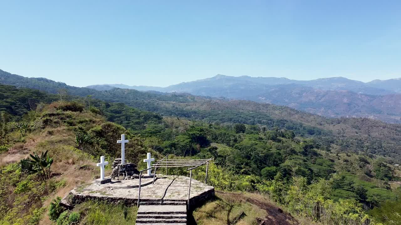 sobrevuelo aéreo 3 cruces blancas crucifijos en el remoto paisaje montañoso del distrito de cultivo de café ermera en timor leste, sudeste de asia