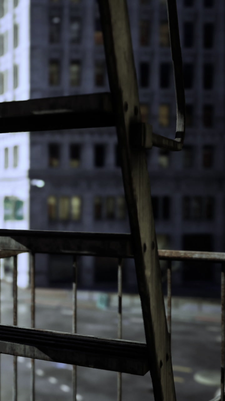 View from a fire escape with a city building in the background at night