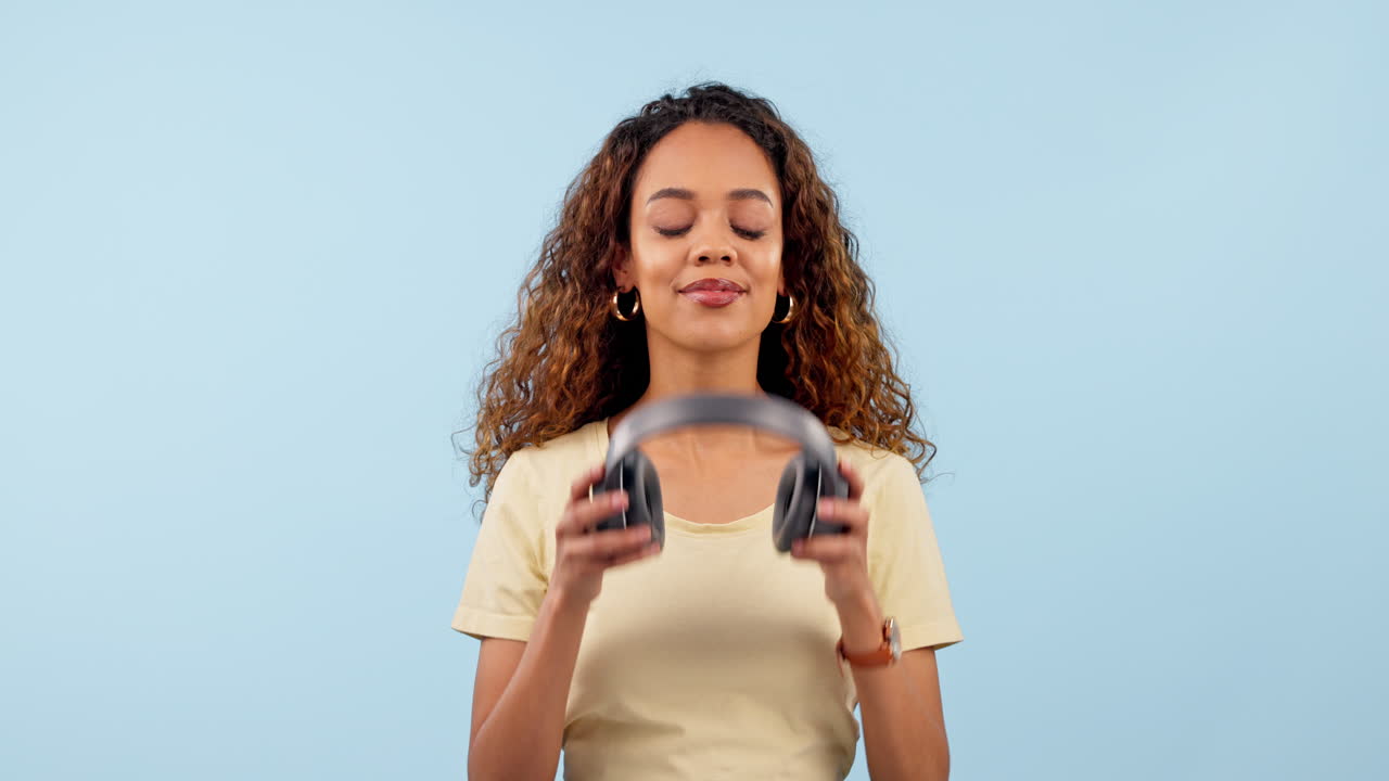Headphones, cellphone and young woman in a studio