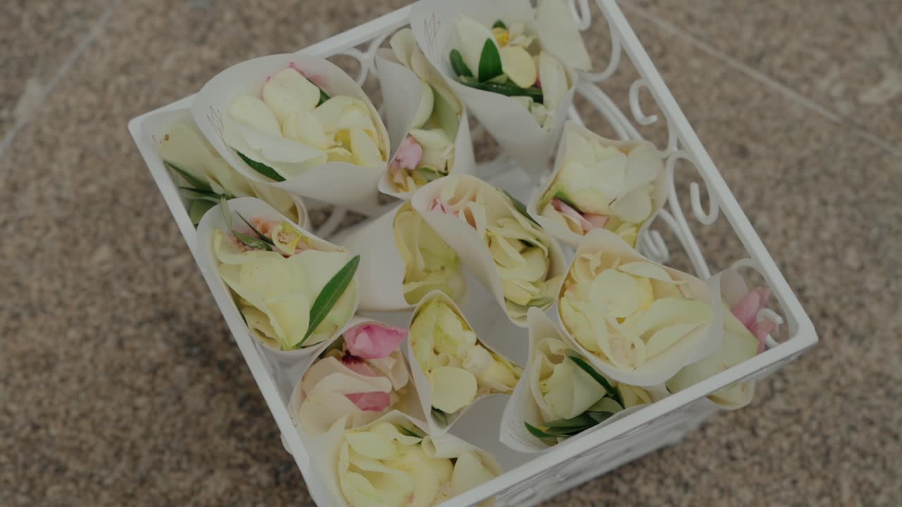 pétalos blancos y rosados en conos de papel, listos para la ceremonia