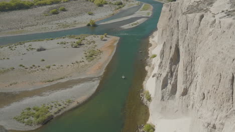 gorgeous wide angle aerial shot of a drift boat floating down the chimehuin river in argentina