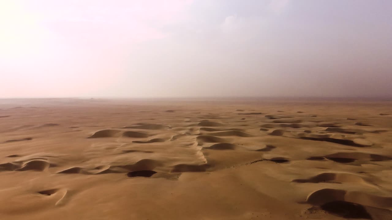 Dune di sabbia infinite nel deserto in un clima estremamente caldo, vista aerea rotante.