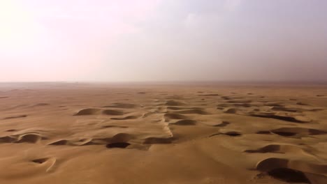 endless sandy desert dunes in extreme hot climate, aerial rotating view