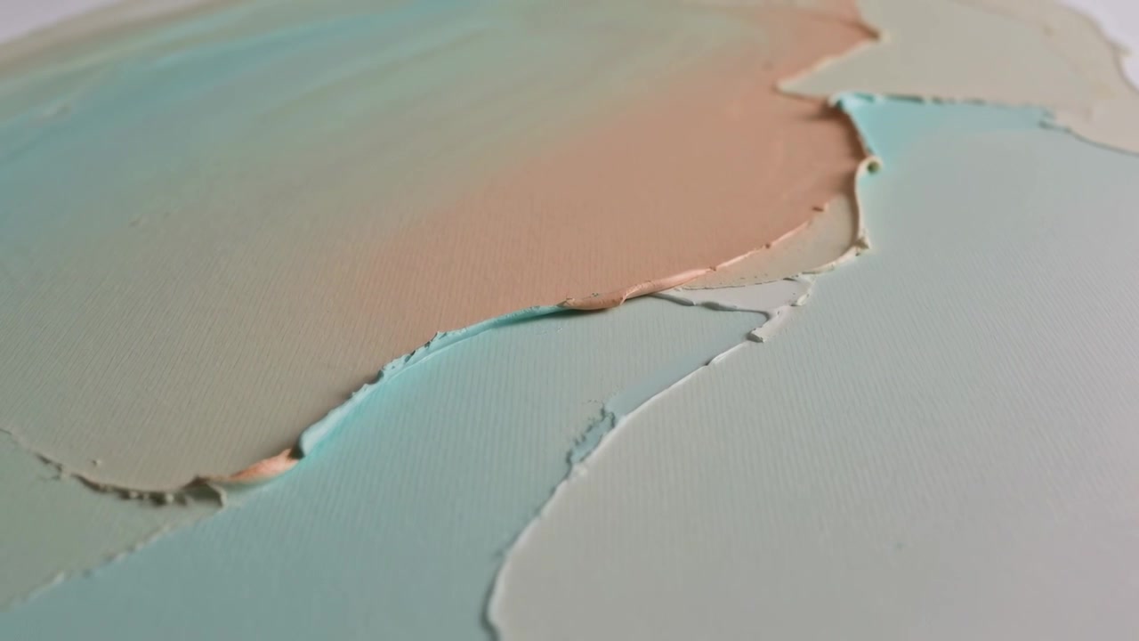 Shifting camera revealing layered pastel paint on studio table, exposing torn edges to show texture