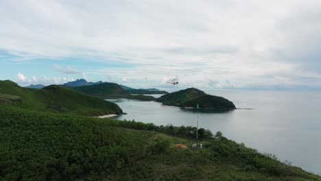 helicóptero se cierne sobre la torre de telecomunicaciones entregando combustible para el generador en la isla, fiji
