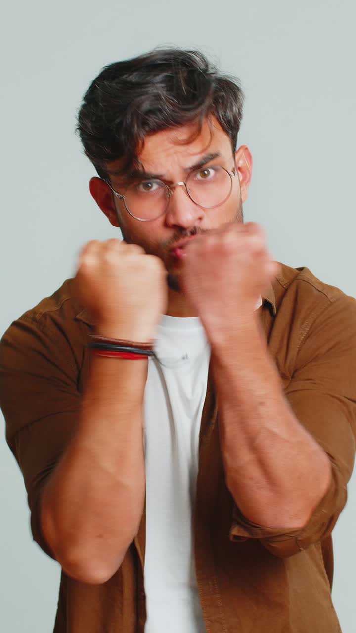 Aggressive angry indian man trying to fight at camera shaking fist boxing punishment threaten