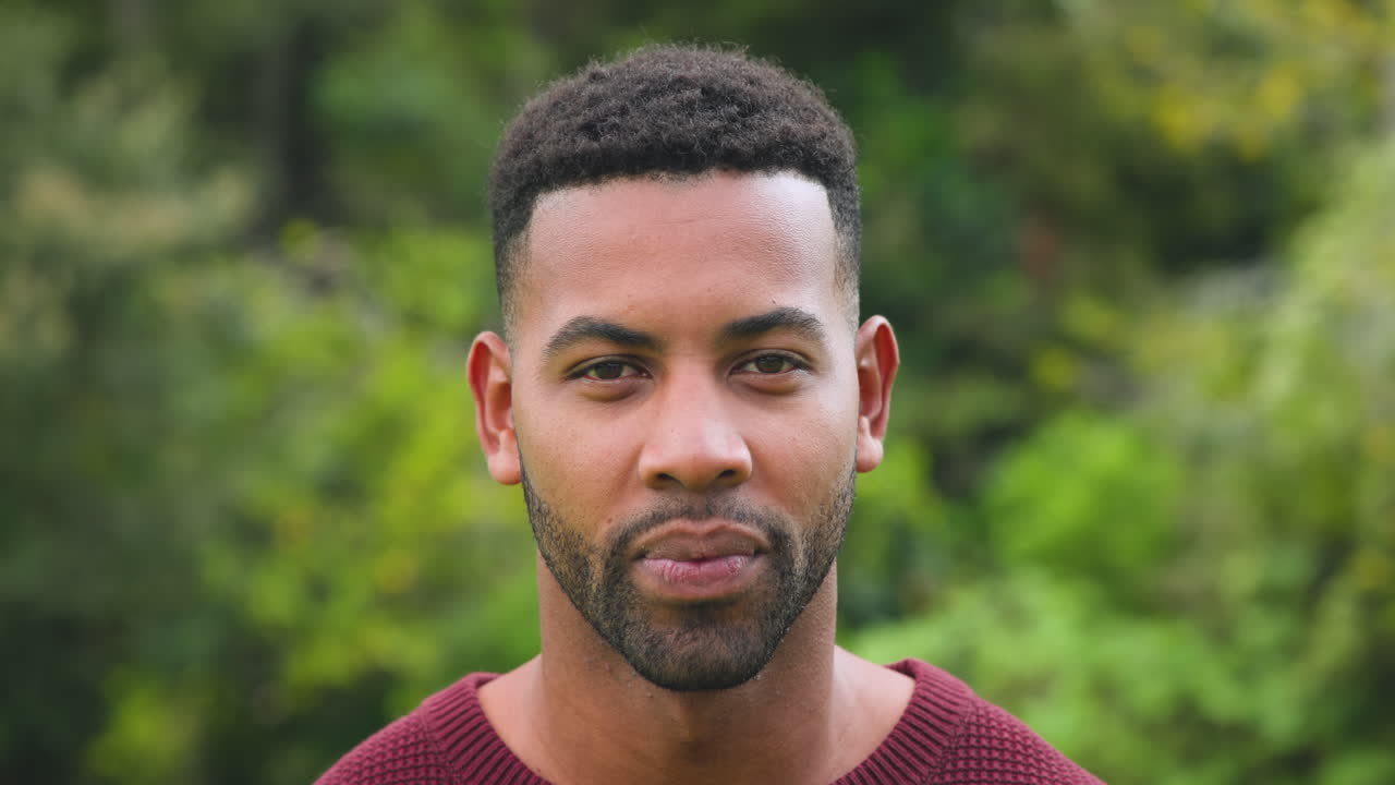 Smiling man enjoying outdoor nature, feeling joyful and relaxed in park