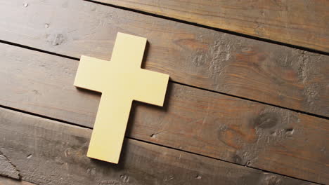 video of yellow christian cross crucifix symbol on old wooden floorboards with copy space